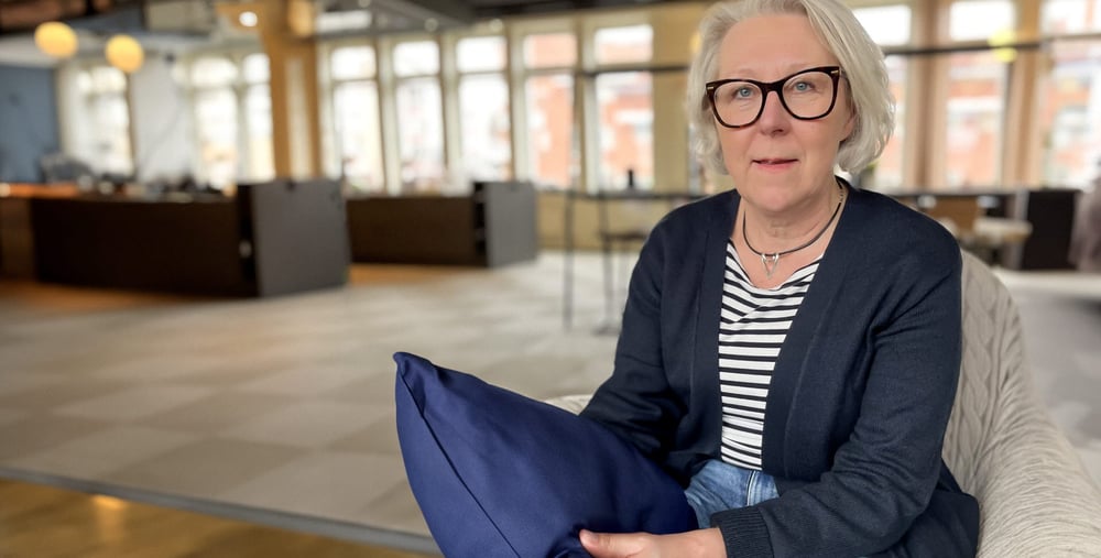 Kvinna i halvfigur med sovkudde i handen