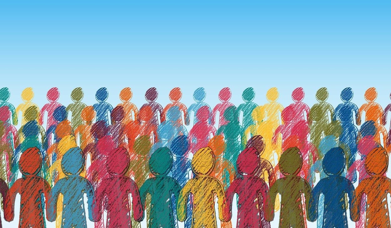 En illustration av en stor folkmassa med siluetter i olika färger mot en blå bakgrund, symboliserande mångfald och gemenskap.