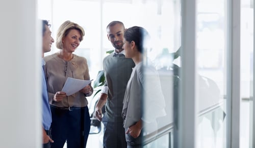 En grupp människor som står runt varandra och pratar.