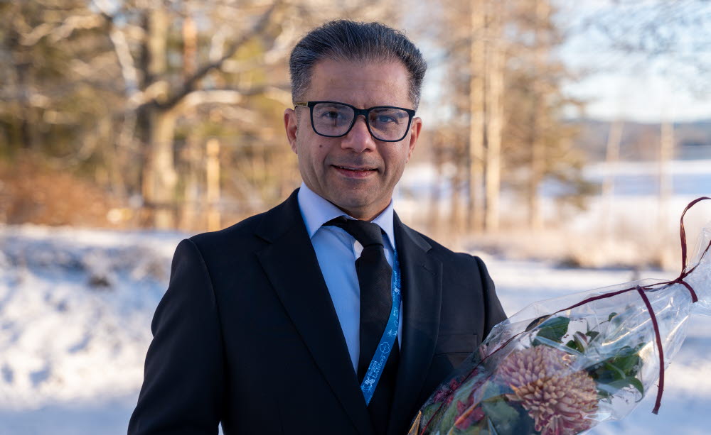 Årets medarbetare, Porträtt av en person i kostym som håller en bukett blommor utomhus i vintermiljö