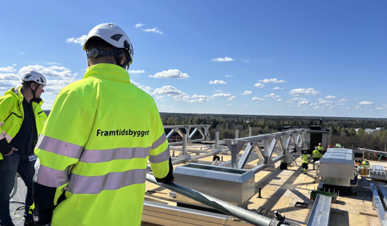 Byggprojektledaren inspekterar bygget av den nya helikopterplattan på taket av hus 60 på Gävle sjukhus. I bakgrunden syns Magnus Busk, programchef för Framtidsbygget.