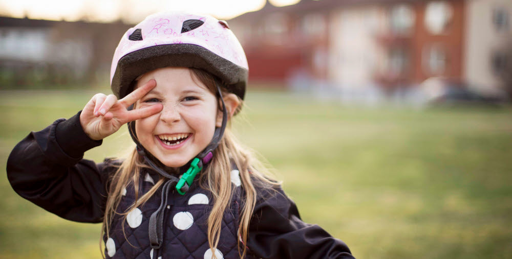 Glatt barn med cykelhjälm