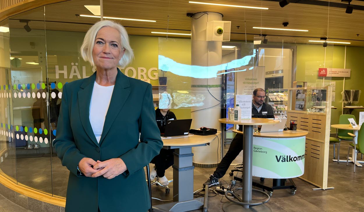 Sjukvårdsminister Acko Ankarberg Johansson (KD) under hennes besök på Gävle sjukhus, här med hälsotorget i bakgrunden. Hon är medelålders, vitt hår i pagefrisyr samt bär vit t-shirt och skogsgrön kostym.